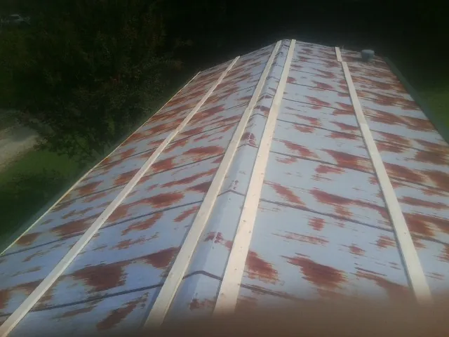 Rusted metal roof panels with new wood purlins before replacement — Storm Damage Roof Repair in Iselin by Roofing Brothers