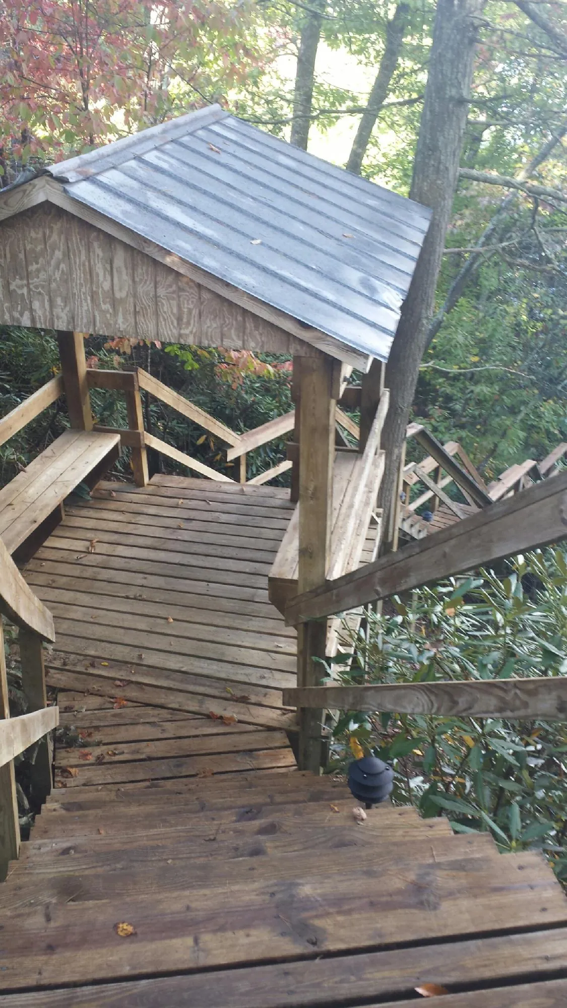 Metal roofed shelter over wooden steps on a wooded walkway — Skylight Repair & Installation work by our crew in Iselin