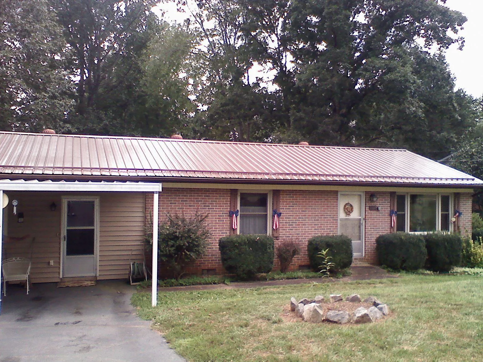 Bronze metal roof and carport on a brick ranch home — Roof Repair work by our crew in Iselin