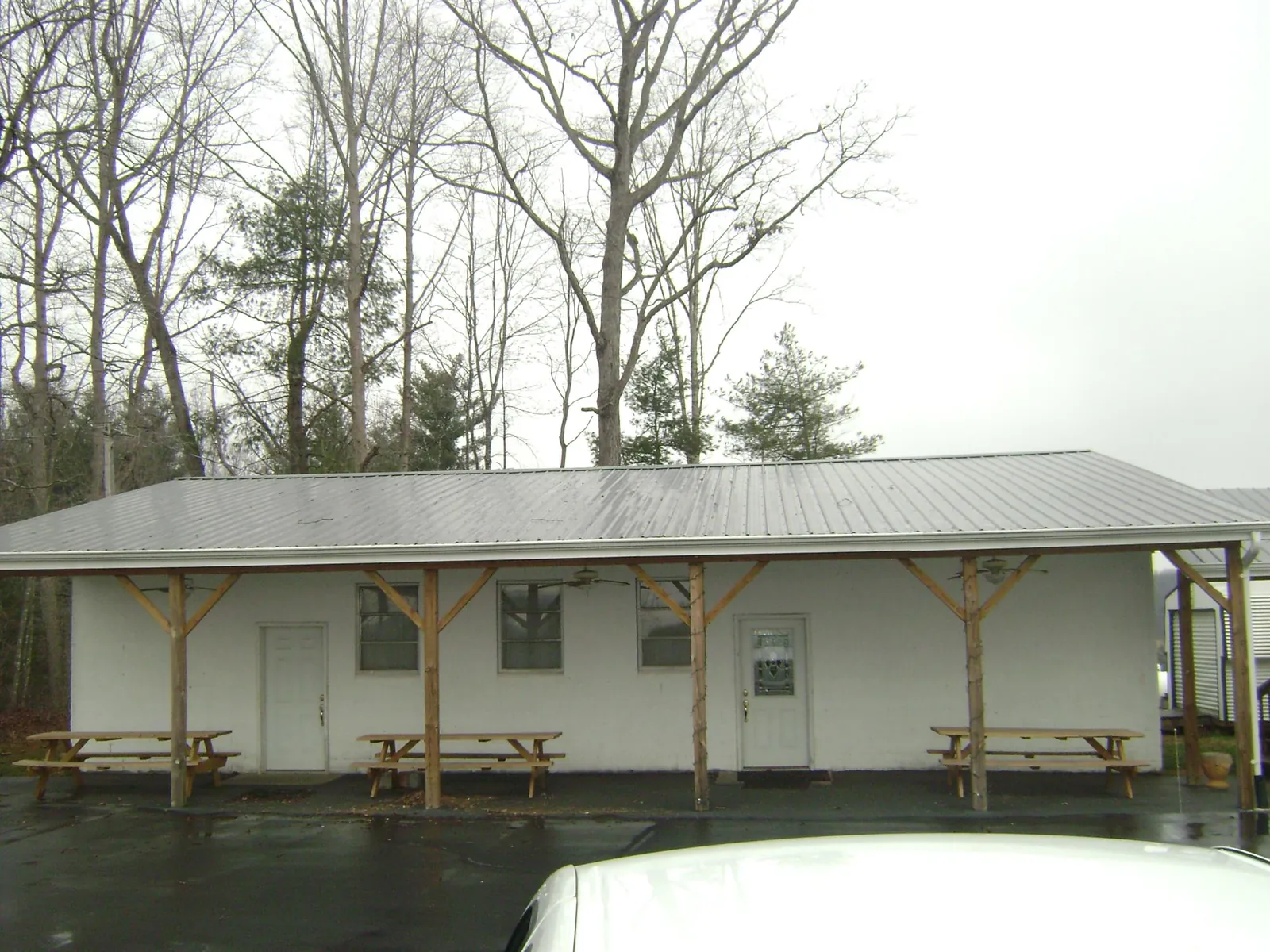 Gray metal roof over a block building with a timber post porch in Iselin